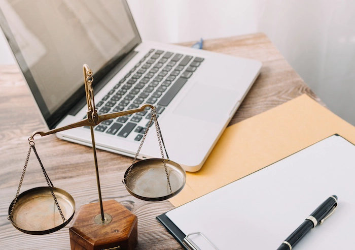 Contact Burns Law Contract papers with brass scale on desk in office
